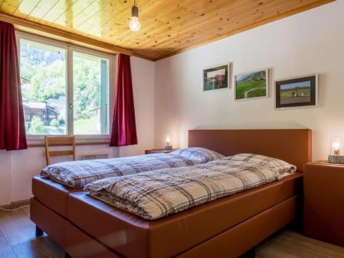 a bedroom with a large bed in front of a window at Beautiful holiday home in Fieschertal with garden in Fieschertal