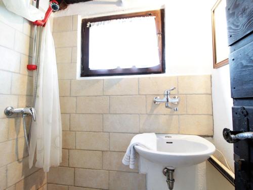 uma casa de banho com um lavatório, um WC e uma janela. em Secluded holiday home in Borgo Valbelluna with garden 