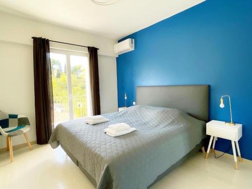 - une chambre bleue avec un lit et une fenêtre dans l'établissement Modern holiday home in Mougins with private pool, à Mougins