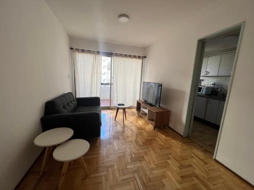 een woonkamer met een bank en een tv bij Departamento de Lis in Mendoza