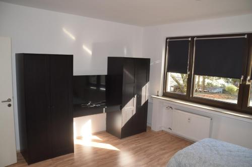 a living room with a black entertainment center and a window at Ruhrbetten in Gelsenkirchen