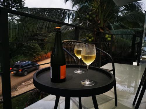 a bottle of wine and two glasses on a table at Hakuna in San Juanillo