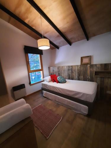 Un dormitorio con una cama grande y una ventana en Orn, Chill Out Houses By A.M.A en San Carlos de Bariloche