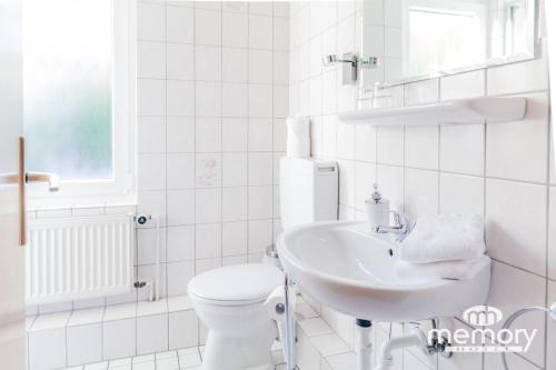 ブラウンラーゲにあるMemory Hotelのトイレと洗面台を備えた白いバスルーム