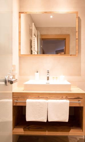 a bathroom with a sink and a mirror at Hotel St. Nikolaus in Ischgl