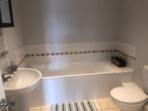 a bathroom with a tub and a toilet and a sink at Ulverston first floor apartment with roof terrace in Ulverston