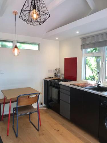 a kitchen with black cabinets and a table and a sink at The Bay Cabin, secluded retreat Freshwater Bay in Freshwater