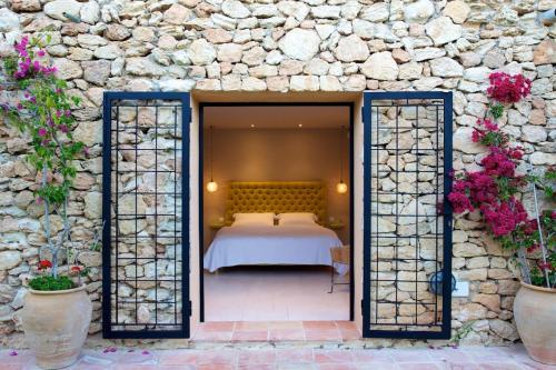 ein Schlafzimmer mit einem Bett in einer Steinmauer in der Unterkunft Exquisite Ibiza Villa I Secluded Hillside Location I Casa Jardin I 6 Bedrooms in San Jose de sa Talaia