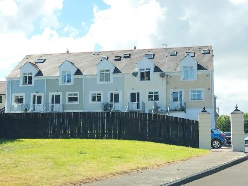 a large white house behind a black fence at Dolmen Apartment Carlingford Lough,Omeath in Ó Méith