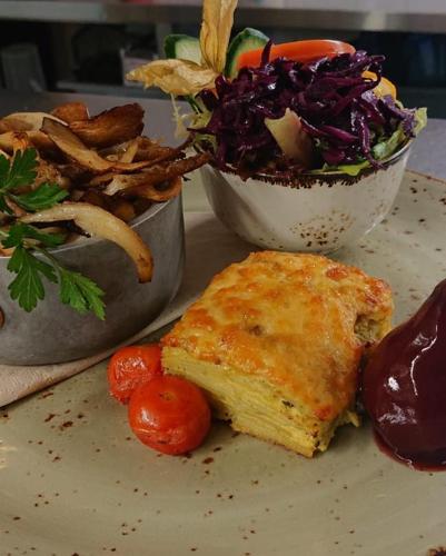 a plate of food with a sandwich and a salad at Herberg Oud Holset in Lemiers