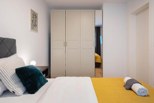a bedroom with a white bed and a closet at Design 2BDR Apartment with Balcony- FREE PARKING in Zagreb