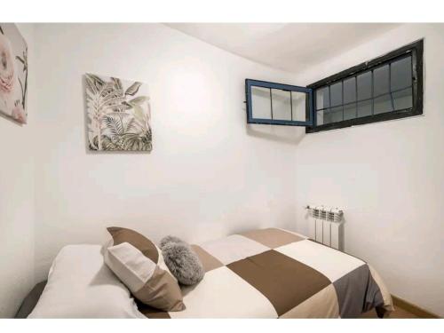 1 dormitorio con cama y ventana en la pared en Apartamento en el centro de Madrid (chueca), en Madrid