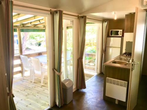 a kitchen with a sliding glass door to a patio at Greenchalets Roquebrune Sur Argens in Roquebrune-sur-Argens