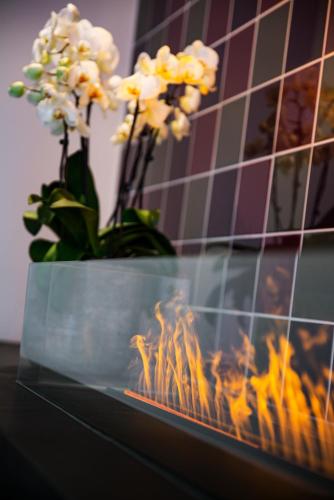 a vase of flowers sitting next to a fireplace at IntercityHotel Geneva in Geneva