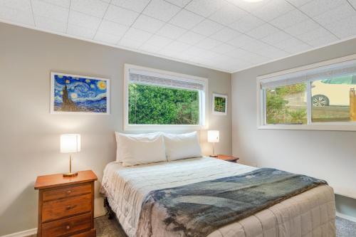 a bedroom with a bed and two windows at The Nook on Chinook in Tillamook