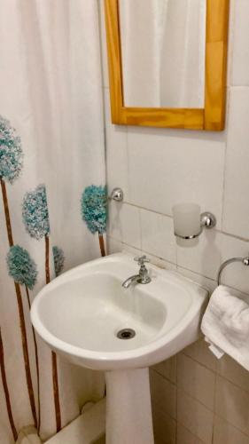 y baño con lavabo blanco y espejo. en Tajy - Monoambiente - Barrio Residencial en Corrientes