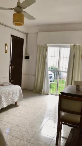 Schlafzimmer mit einem Bett und einer Glasschiebetür in der Unterkunft Tajy - Monoambiente - Barrio Residencial in Corrientes