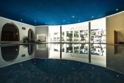 an indoor swimming pool in a house with a ceiling at Hotel Peter in Petersberg
