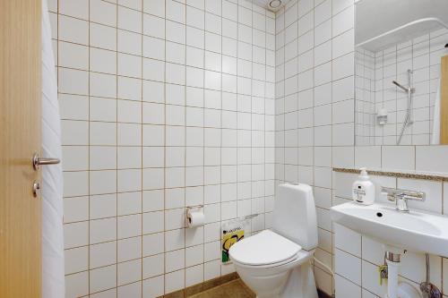 a white bathroom with a toilet and a sink at Danhostel Hillerød in Hillerød