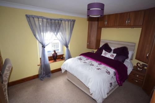 a bedroom with a large bed and a window at Ulverston Centre Superb 3 Double Bedroom Apartment in Ulverston