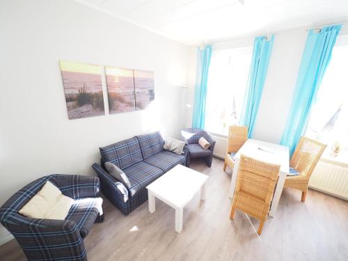 a living room with a couch and chairs and a table at Haus Neptun App. 4 in Westerland (Sylt)