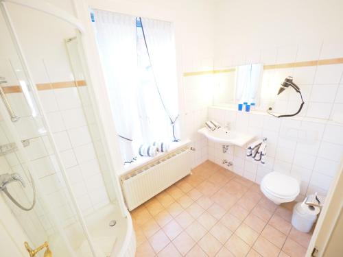 a bathroom with a shower and a toilet and a sink at Haus Neptun App. 4 in Westerland (Sylt)