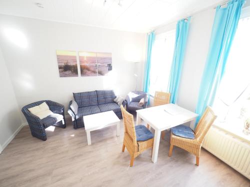 a living room with a couch and a table and chairs at Haus Neptun App. 4 in Westerland (Sylt)