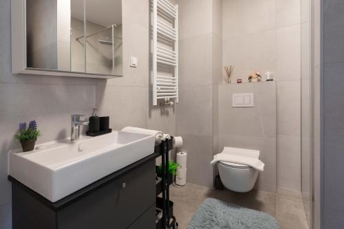 a white bathroom with a sink and a toilet at Design 2BDR Apartment with Balcony- FREE PARKING in Zagreb
