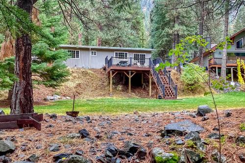 a house with a porch and a deck in the woods at Riverbend in Joseph