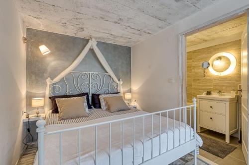 1 Schlafzimmer mit einem weißen Bett mit einem weißen Kopfteil in der Unterkunft Villa Targeto with Sea View in Trget