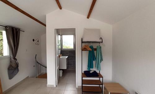 un couloir d'une maison avec une salle de bains et un escalier dans l'établissement Maison 38m2 15min de Corte 30min de Bastia, à Bigorno