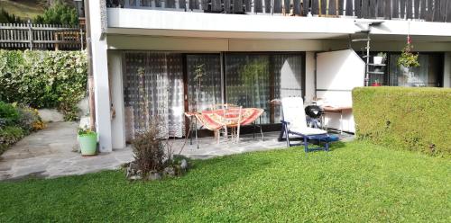 d'une terrasse avec une table et des chaises dans la cour. dans l'établissement Bonavau studio3, à Champéry