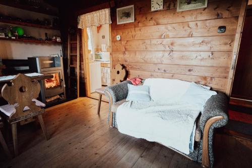 1 dormitorio con 1 cama y pared de madera en chata u Tesáku, en Rajnochovice