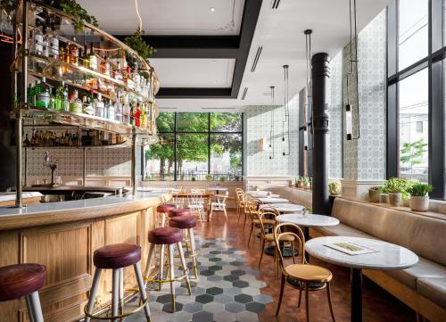 a restaurant with a bar with stools and tables at The Broadview Hotel in Toronto