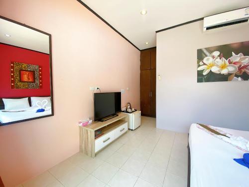 a living room with a tv and a bed at MA MAISON BOUTIQUE HOTEL. in PHUKET in Bang Tao Beach