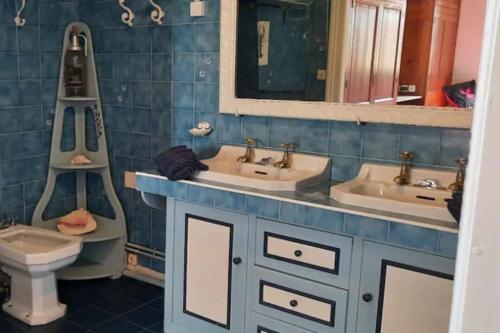 a bathroom with two sinks and a toilet and a mirror at Villa d'Artiste 200m de la plage! in Arcachon