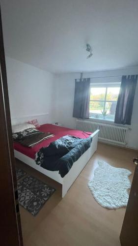 een slaapkamer met een bed met een rode deken bij Wohnung am Mittellandkanal in Bohmte