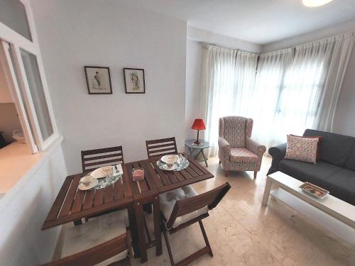 een woonkamer met een tafel en stoelen en een bank bij Carlos Cañal in Sevilla