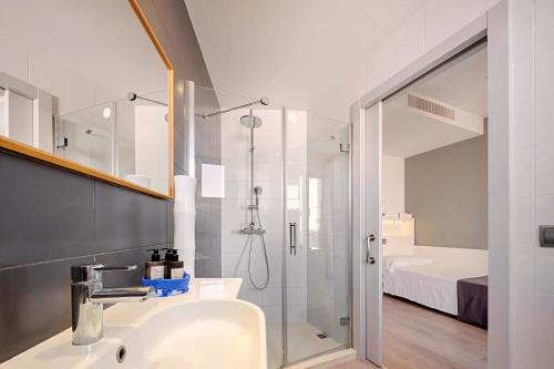 a bathroom with a sink and a shower with a shower at Mar Calma Hotel in Port de Pollensa