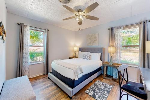 a bedroom with a bed and a ceiling fan at Suniland Cottage in Fredericksburg