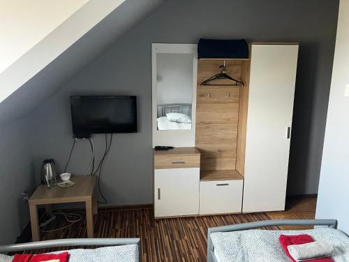 a room with a bed and a closet with a tv at Wisełka in Płock
