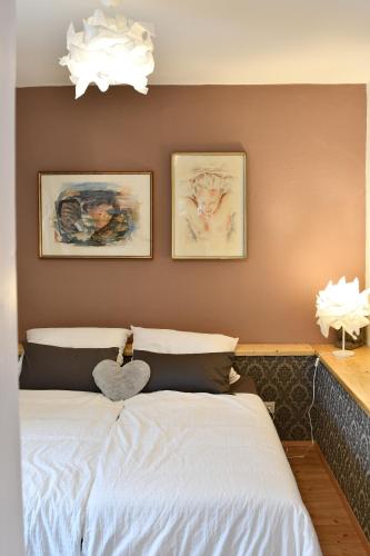 a bedroom with a bed with two pictures on the wall at Heimat Floral Ferienwohnung in Wadgassen