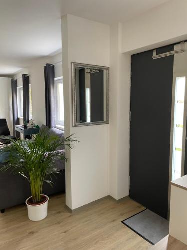 a living room with a black door and a plant at Ruhiges Appartement im Grünen in Graz