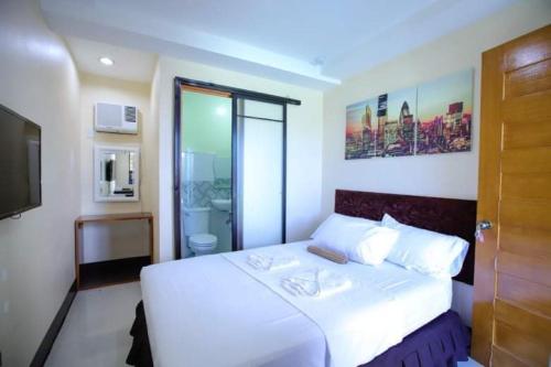 - une chambre avec un lit blanc et une salle de bains dans l'établissement Marco s Tourist Inn by RedDoorz, à Leyte