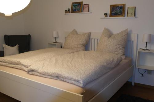 a bedroom with a white bed with pillows and a tv at Ferienwohnung Casa Bella 