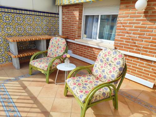 two chairs and a table on a patio at APARTAMENTOS TURISTICOS SEVIRO Benidorm in Benidorm