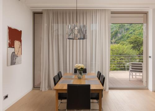 a dining room with a table and chairs and a window at Dukley Hotel & Resort in Budva