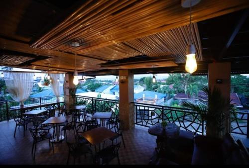un restaurant avec des tables et des chaises sur une terrasse dans l'établissement Marco s Tourist Inn by RedDoorz, à Leyte