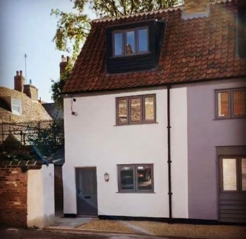 une maison blanche avec une fenêtre au-dessus dans l'établissement Grade II Listed 2 Bed Cottage with Free Parking, à King's Lynn