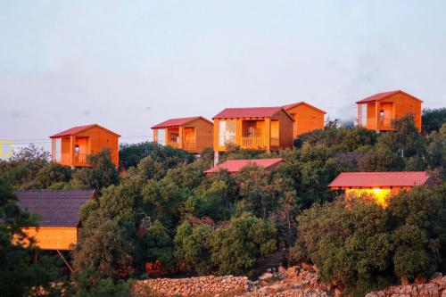 una fila de casas en la cima de una colina en Ajloun Wooden Huts اكواخ عجلون الخشبية Live amid nature, en Umm al Manābī‘